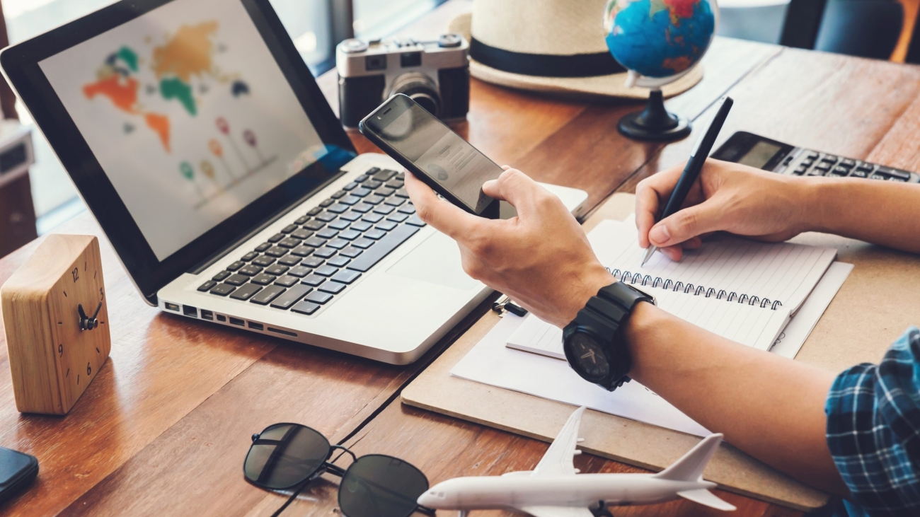 Young men planning vacation trip and searching information or booking an hotel on a smart phone and laptop.travel , trip vacation,