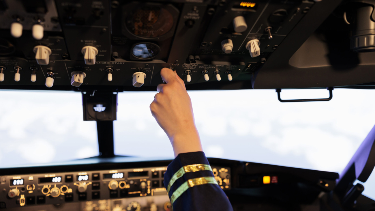 Female copilot pushing buttons and switch on dashboard panel, flying airplane with navigation and control command. Using power engine lever and radar compass to takeoff with plane. Close up.
