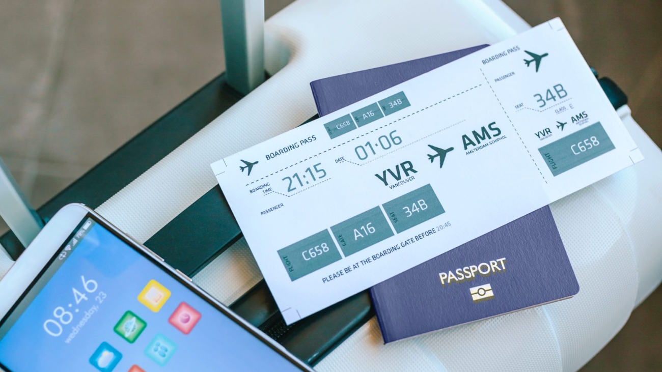 Top view of suitcase with air ticket, passport and cell phone